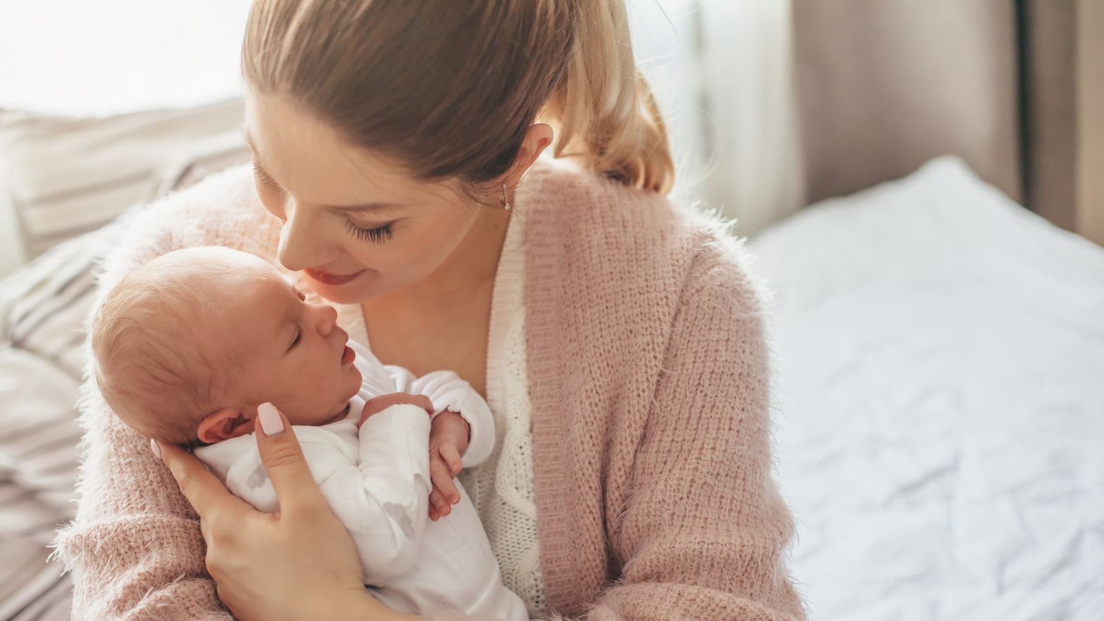 Woman holding and looking at newborn baby