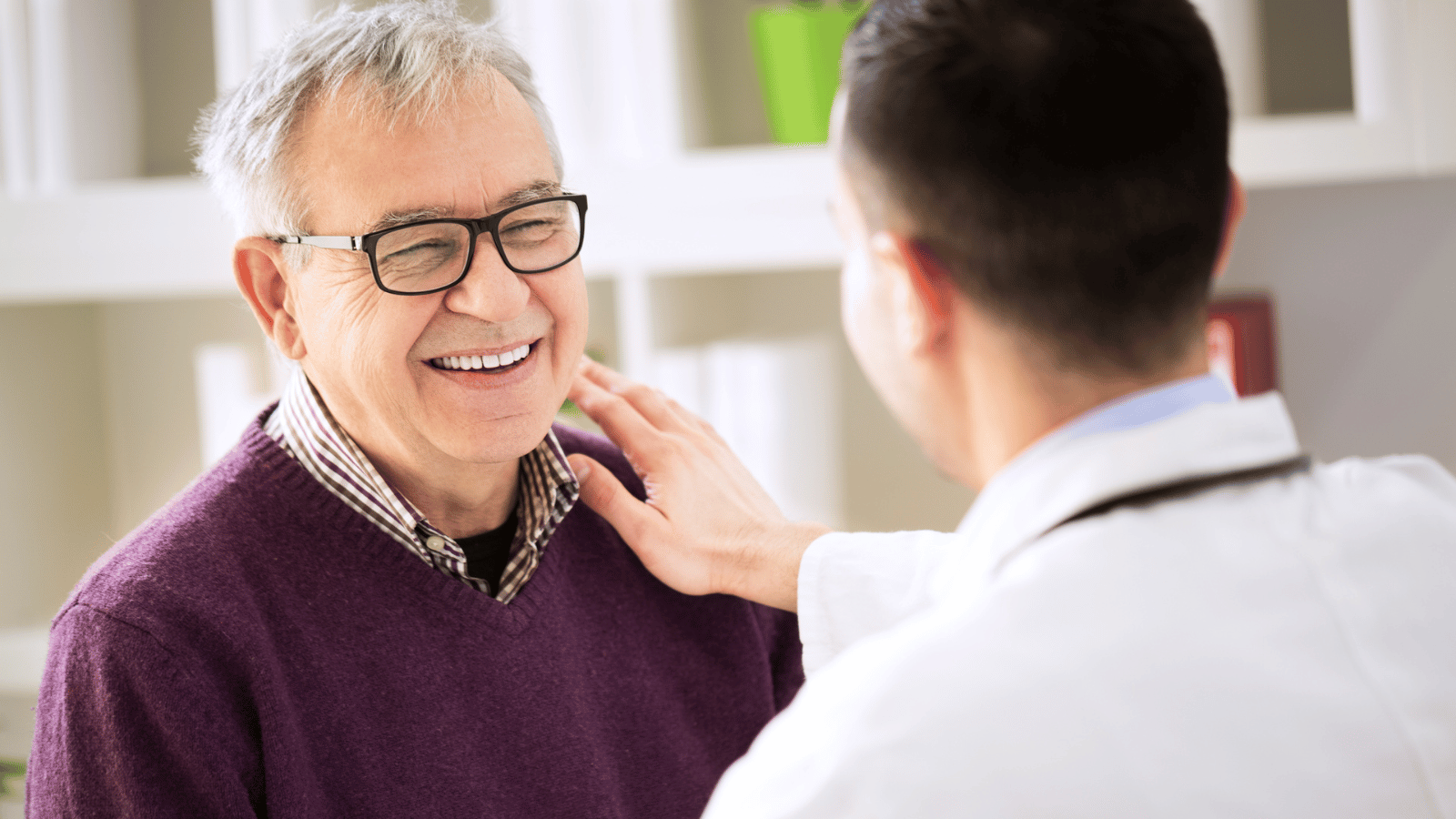 Doctor talking to older man who is smiling