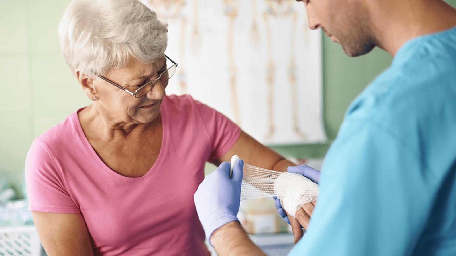 Elderly patient receiving a new bandage on her arm